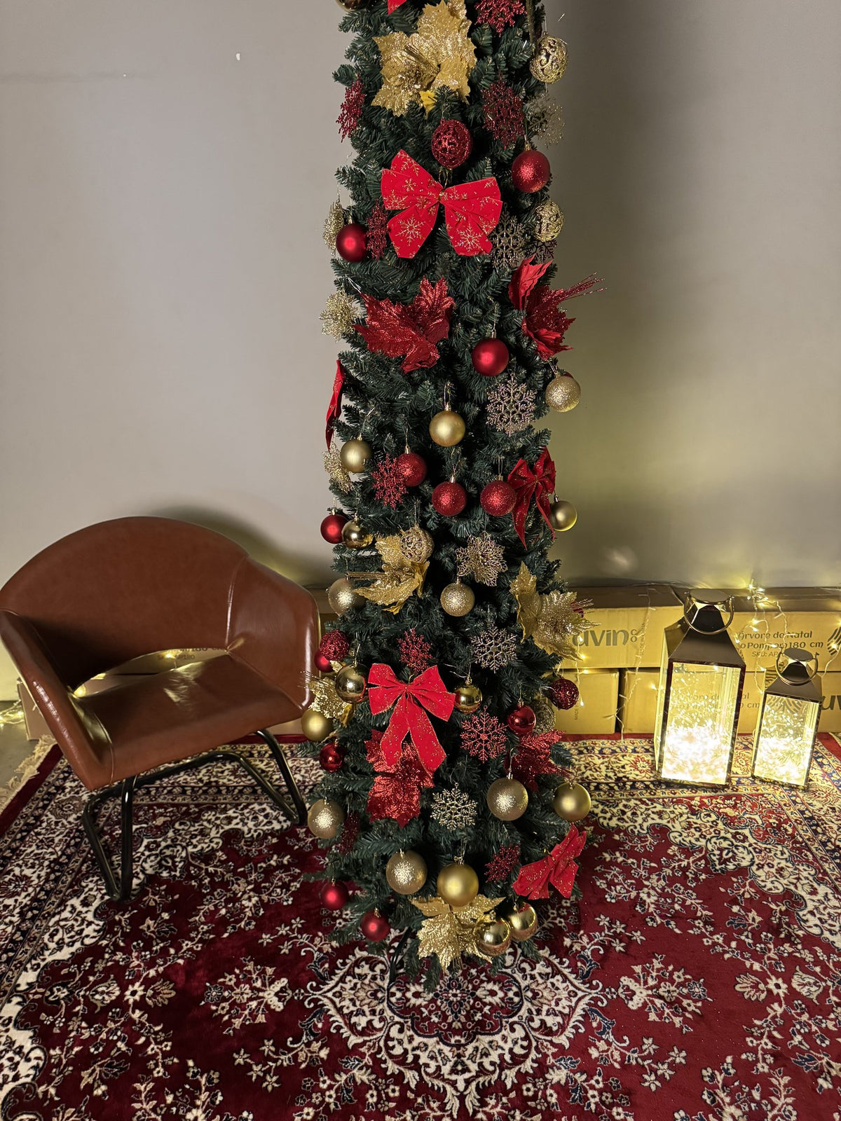 Árvore slim de 2,40 m decorada com laços vermelhos, flores e bolas douradas, vista de perto