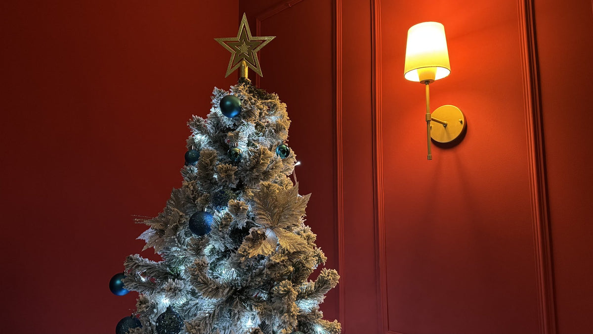 Árvore nevada de 1,80 m decorada com bolas azuis, laços dourados, estrela e luzes brancas, em detalhe