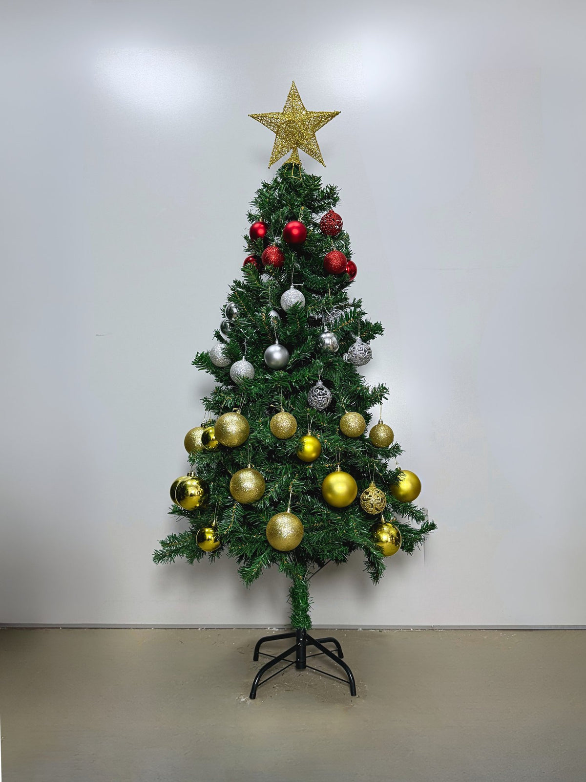 Pinheiro canadense tradicional de 1,50 m decorada com bolas vermelhas, prateadas e douradas e estrela dourada, em fundo claro