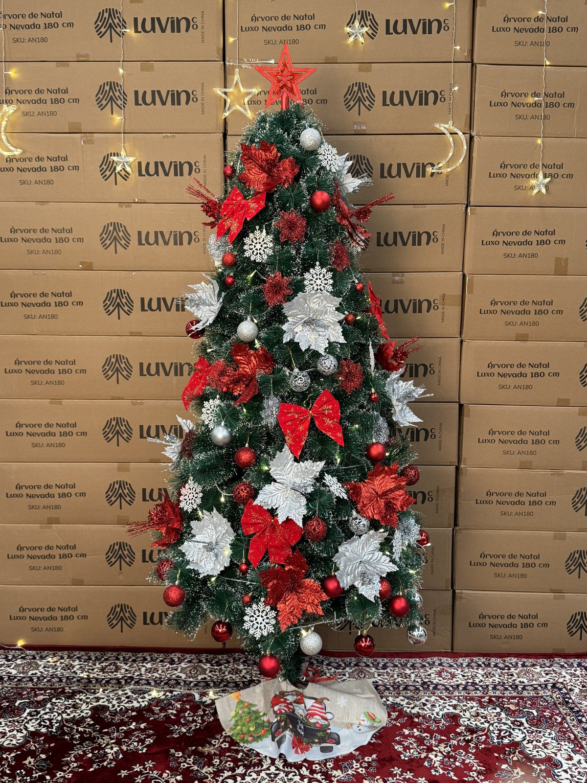 Árvore pompom com pontas nevadas de 2,10 m decorada com laços, flores e bolas vermelhas e prateadas, vista de corpo inteiro